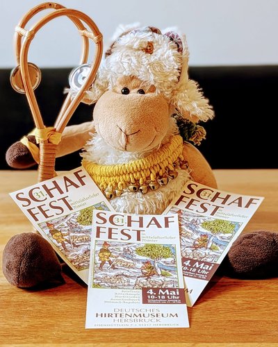 Das Stoffschaf Luise, das auf Flyern des Schaffests in Hersbruck sitzt